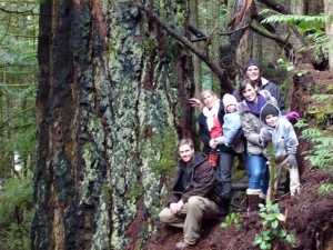 Family enjoying the Artist Walk Day in the Wilson Creek Forest stop for a family picture by 'Mus-swiya's Tree'